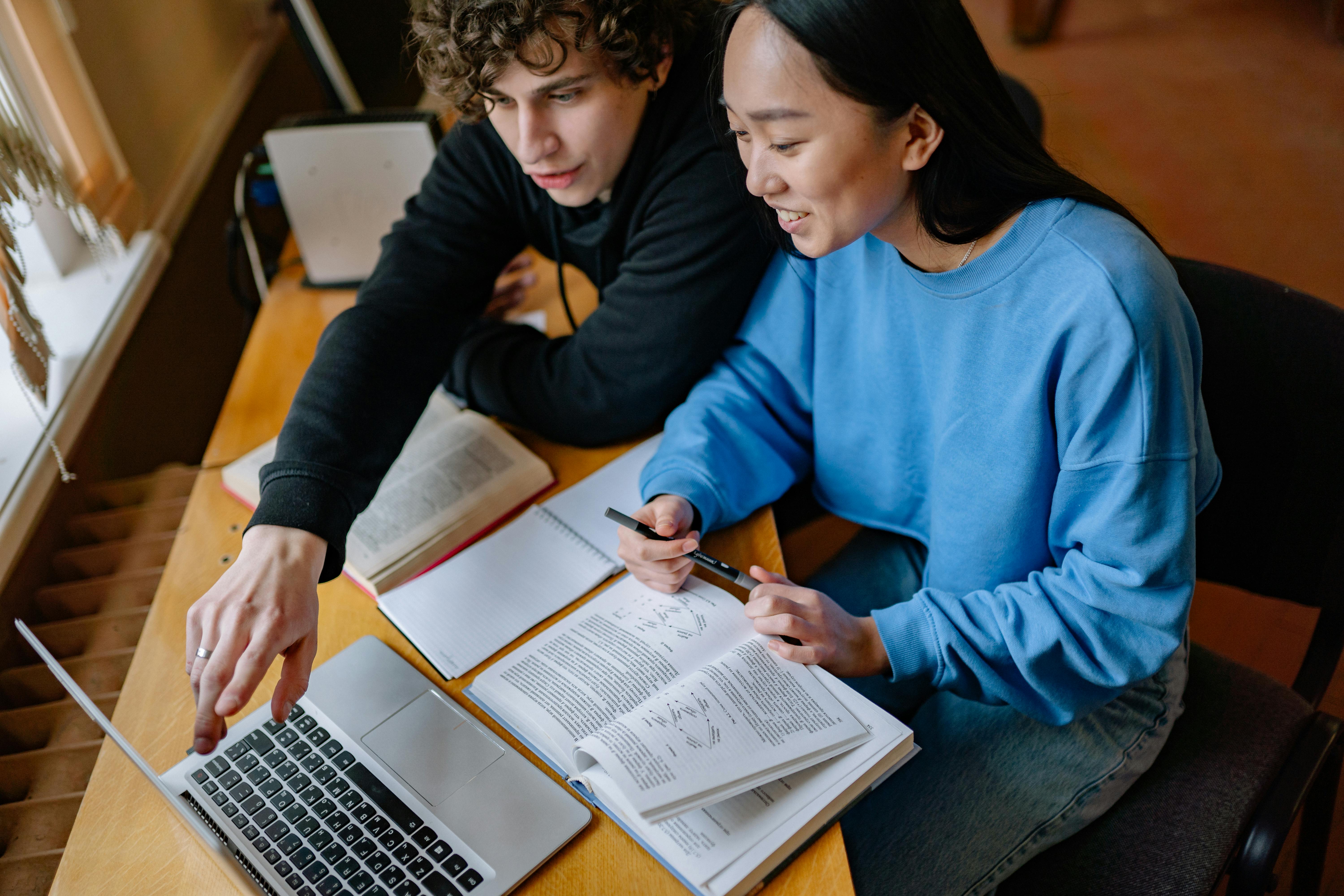 Students studying together while looking at laptop screen